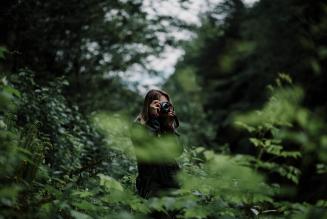 Image of woman taking photos in forest
