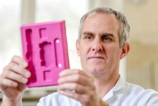 Master colour blender Mark Starrs analysing a piece of moulded paper packaging in the colour lab