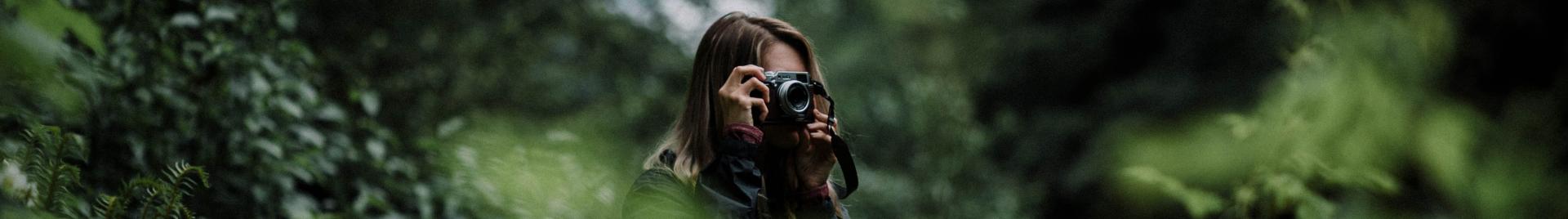 Image of woman taking photos in forest